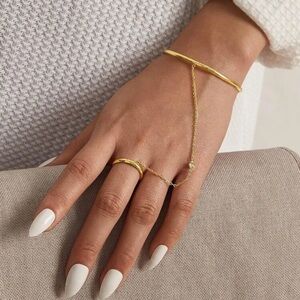 Gold tone bangle bracelet with hand chain and a solid band ring - adjustable